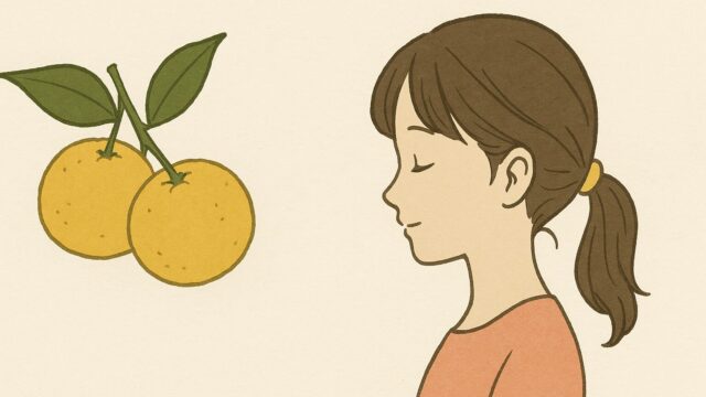 やさしい表情で目を閉じるポニーテールの少女と、横に並ぶ2つの黄色い柚子の実が、オフホワイトの背景に描かれている。柚子には緑の葉がついており、全体は落ち着いたトーンでまとめられている。