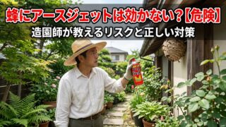 庭で蜂の巣（アシナガバチ）にアースジェット（ハエ・蚊用）を向け、リスクと対策を考える造園師の男性。